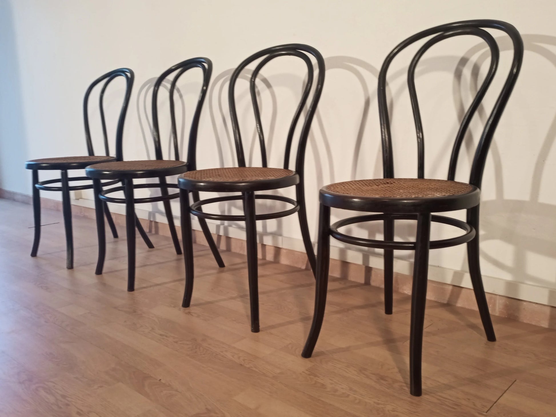 Set di 4 sedie da pranzo thonet italia in faggio curvato nero con sedile in legno disposte in fila
