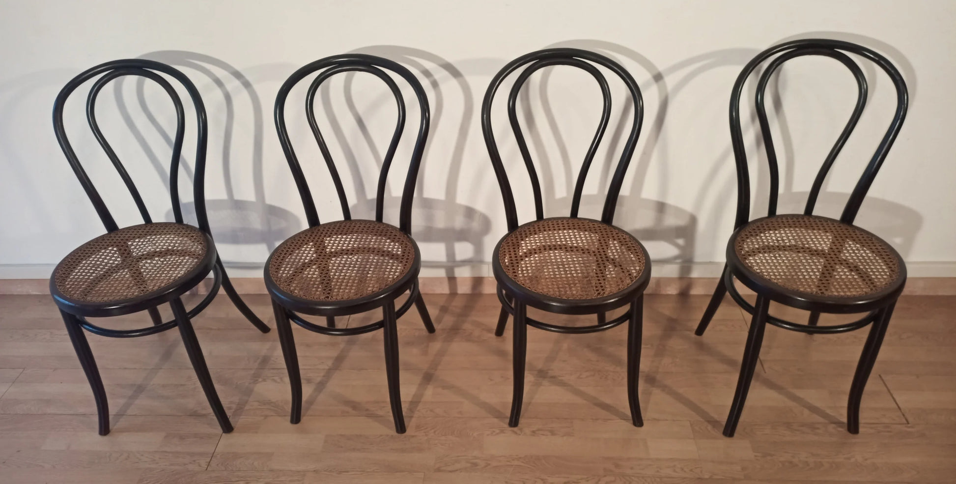 Set di 4 sedie da pranzo in faggio curvato con seduta in canna nello stile thonet italia disposte in fila